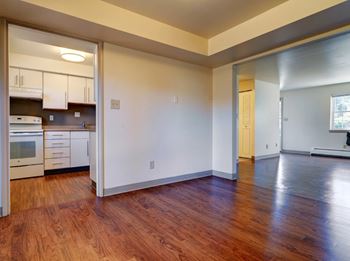 A kitchen with white cabinets and a wooden floor